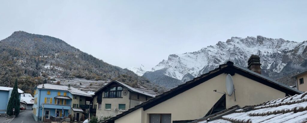 View of snowy alps from the upper window of house